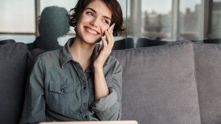 Mujer hablando por celular y sonriendo