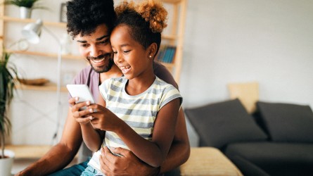 Padre revisando celular con su hija