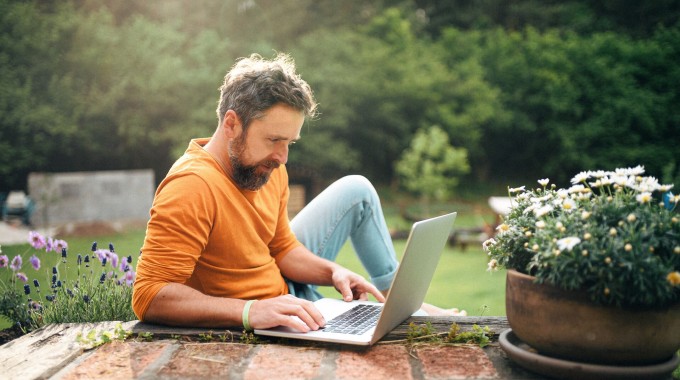 Hombre revisando su computador en el patio