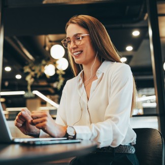 Mujer sonriendo y mirando su computador