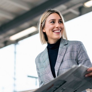 Mujer sonriendo con diario en las manos