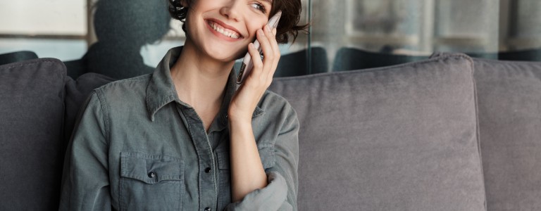 Mujer hablando por celular y sonriendo